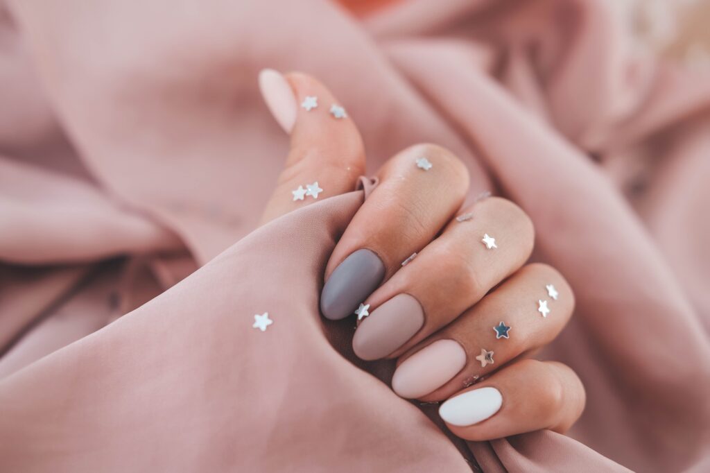 Women - hand with beautiful manicure hold a silk fabric.